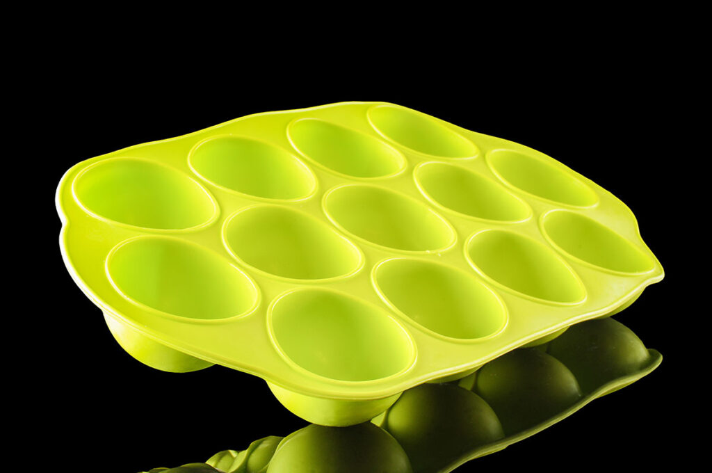Green-silicone-ice-cube-tray-isolated-on-the-black-background