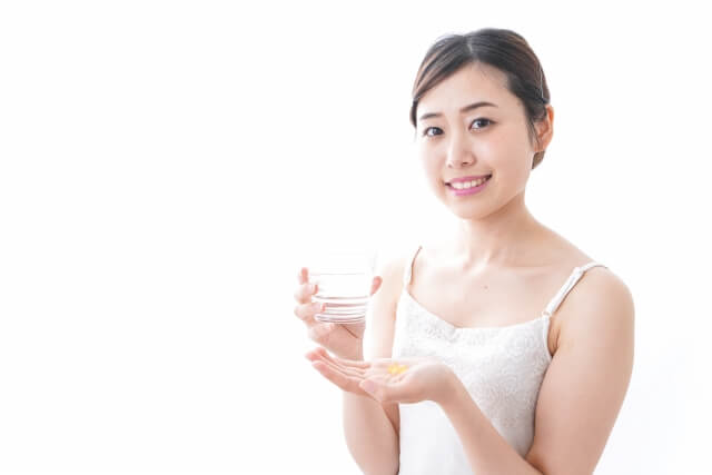 薬を水で飲む女性