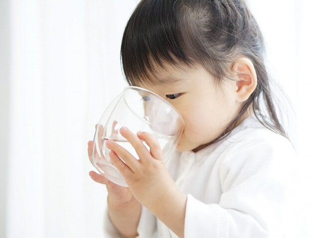 コップの水を飲む子ども